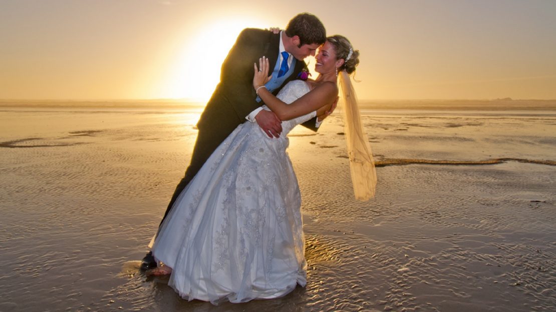fotografía post-boda amanecer playa con loa pies en el agua.