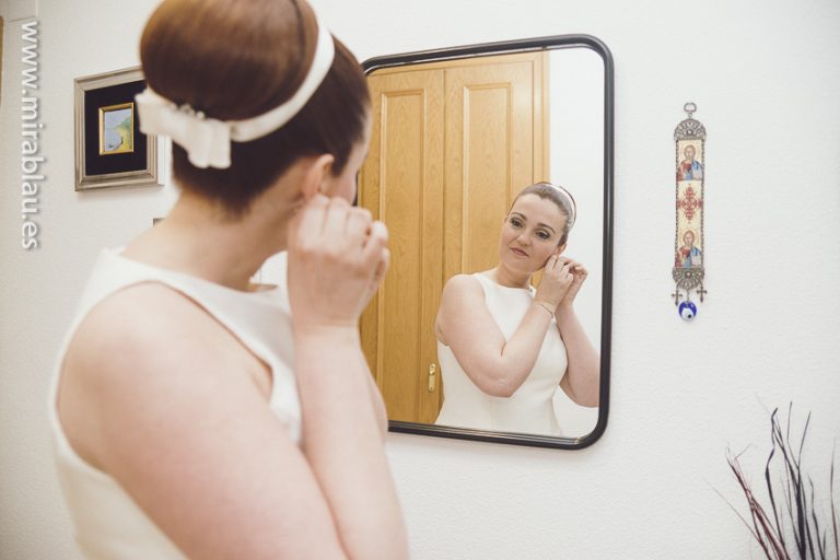 Novia frente a espejo retoca pendientes