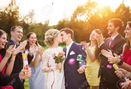 35800941-Full-length-portrait-of-newlywed-couple-and-their-friends-at-the-wedding-party-showered-with-confett-Stock-Photo-1024x697